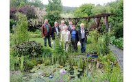  - Gruppenbild im Regen: Die Gastgeber und die Ehrengäste im Garten der Familie Schneck. Foto: Langer/Landkreis Regen