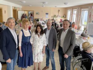 Unser Bild zeigt (v.li.) Dr. Ronny Raith (stellvertretender Landrat), Heidi Mirski (Prokuristin Unternehmensgruppe Mirski), Heimleiterin Jasmin Hoffmann, Sozialamtsleiter Horst Kuffner und Bürgermeister Robert Muhr im vollbesetzten Aufenthaltsraum des Seniorenheimes. Foto: Heiko Langer/Landratsamt Regen