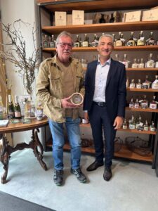 Landrat Dr. Ronny Raith überreicht Brennmeister Herbert Kammermeier auf Gut Oberfrauenau das Persönliche Geschenk des Landrats. Foto: Iris Gehard / Landratsamt Regen