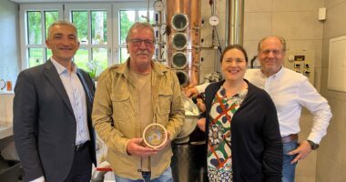 Blick in die Brennerei des Guts Oberfrauenau (v.li.): Landrat Dr. Ronny Raith, Brennmeister und Geehrter Herbert Kammermeier und Inhaberehepaar Alexandra und Benedikt von Poschinger vor der Brennblase, in der schon viel edles Hochprozentiges entstanden ist. Foto: Iris Gehard / Landratsamt Regen