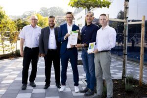 Bildunterschrift: (v.l.) R&S-Abteilungsleiter Michael Loibl, Bürgermeister Daniel Graßl, R&S-Werkleiter Florian Bielmeier, Landrat Dr. Ronny Raith und R&S-Umweltmanagementbeauftragter Alexander Wiederer bei der Urkundenübergabe. Foto: Thomas Gierl/Rohde & Schwarz