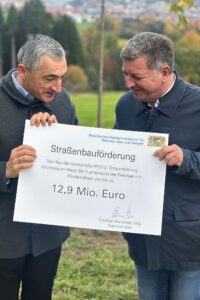 Da konnte sich Landrat Dr. Ronny Raith (li.) freuen: Staatsminister Christian Bernreiter überreichte einen symbolischen Förderscheck. Der Freistaat fördert die Baumaßnahme mit 80 Prozent, insgesamt bis zu 12,9 Millionen Euro können so in den Umgehungsstraßenbau - vom Freistaat kommend – fließen. Foto: Heiko Langer / Landratsamt Regen
