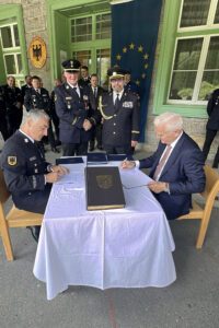Regens Landrat Dr. Ronny Raith (sitzend, li.) und der Pilsener Regionspräsident Dr. Kamal Farhan (sitzend, re.) waren die ersten Unterzeichner. Regens Kreisbrandrat Hermann Keilhofer und der Pilsener Feuerwehrgeneral František Pavlas reichten sich die Hände zur Zusammenarbeit. Foto: Heiko Langer / Landratsamt Regen