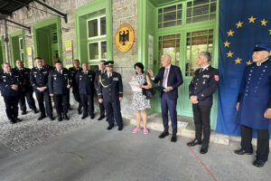 Regionspräsident Dr. Kamal Farhan sprach sein Grußwort, übersetzt von Petra Kropáčková, auf der deutschen Seite der Grenze stehend, während Regens Landrat Dr. Ronny Raith im Nachbarland Tschechien zuhörte. Foto: Heiko Langer / Landratsamt Regen