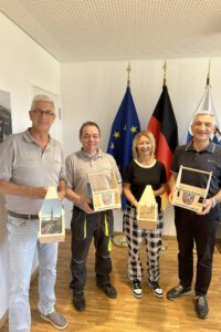 Sie präsentieren stolz das Landkreis-Regen-Tragerl, v.li.: Dr. Thomas Koy (Eigentümer Firma Holz.Lieb.ich), Produktionschef Thomas Klimmer (Holz.Lieb.ich), Fotografin Alexandra Linzmeier und Regens Landrat Dr. Ronny Raith. Foto: Heiko Langer / Landratsamt Regen