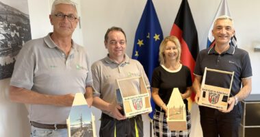 Sie präsentieren stolz das Landkreis-Regen-Tragerl, v.li.: Dr. Thomas Koy (Eigentümer Firma Holz.Lieb.ich), Produktionschef Thomas Klimmer (Holz.Lieb.ich), Fotografin Alexandra Linzmeier und Regens Landrat Dr. Ronny Raith. Foto: Heiko Langer / Landratsamt Regen