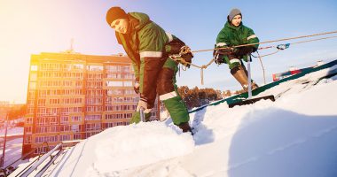 Männer schaufeln Dach ab. Foto: AdobeStock.com / © Parilov