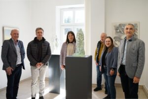 Christian Bayerl, Glaskünstler Erwin Schmierer, Wirtschaftsförderin Teresa Sitzberger, Kurator Fritz Bauer, Tourismusreferentin Elisabeth Unnasch und Landrat Dr. Ronny Raith (v.l.) tauchen mitten in die Ausstellung „Spektrum“ ein – geführt vom Künstler selbst, der seine Werke zwischen Licht, Glas und Perspektive lebendig werden lässt. Foto: Miriam Lange / Landratsamt Regen.