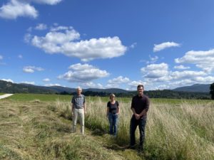 Hans-Jörg Gaim von der LBV-Kreisgruppe Regen, Landwirtin Manuela Berndl und Biodiversitätsberater Martin Graf vor der frisch gemähten Wiese. Foto: Emily Oswald/Landratsamt Regen