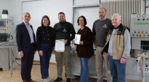 Bei der Übergabe der Umwelt- und Klimapakt-Urkunde an die Schreinerei Geiger: (v. li.) Landrat Dr. Ronny Raith, Wirtschaftsförderin Teresa Sitzberger, Betriebsinhaber Franz Geiger, Silke Geiger, Mitarbeiter Daniel Sennebogen und Seniorchef Johann Geiger. Foto: Melanie Reif / Landkreis Regen.