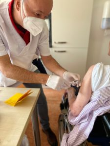 Bilduntertitel: Impfarzt Dr. Spinean versorgt eine Heimbewohnerin mit einer Auffrischimpfung (Foto: Julia Bauer/Impfzentrum).