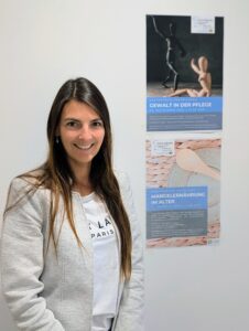 Melanie Feldmann (Geschäftsstellenleiterin der Gesundheitsregionplus Arberland) präsentiert die beiden Veranstaltungsplakate zu den kostenfreien Fortbildungsangeboten. Foto: Jenny Löhr / Landratsamt Regen