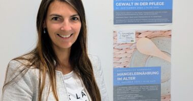 Melanie Feldmann (Geschäftsstellenleiterin der Gesundheitsregionplus Arberland) präsentiert die beiden Veranstaltungsplakate zu den kostenfreien Fortbildungsangeboten. Foto: Jenny Löhr / Landratsamt Regen