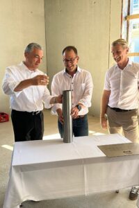 Landrat Dr. Ronny Raith, Schulleiter Andreas Loibl und Architekt Robert Brunner befüllten die Zeitkapsel. Foto: Heiko Langer / Landratsamt Regen