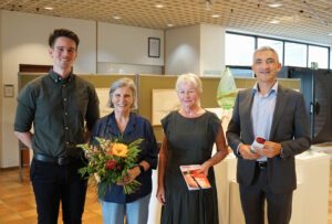 Kunst betrachtet sich am besten nicht im Vorbeigehen: Landrat Dr. Ronny Raith (re.) ließ sich von der künstlerischen Leiterin Annemarie Pletl (2. v. re.) und Reinhard Wölfl (li.), Vorsitzender der Sektion Zwiesel des Bayerischen Wald-Vereins, durch den 62. Zwiesler Buntspecht führen. Zum gemeinsamen Foto kam auch Ursula Mühl hinzu – samt Blumenstrauß als Dankeschön für ihren unermüdlichen Einsatz an der Ausstellungskasse, die sie während der gesamten Laufzeit betreut. Foto: Miriam Lange / Landratsamt Regen.