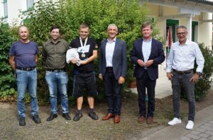 Ein glänzender Empfang: Landrat Dr. Ronny Raith (4. v. li.) und die Regener Werkstätten mit (v. li.) Gruppenleiter Wolfgang Loibl, Werkstattleiter Manuel Troiber, dem Zweiten Vorstandsvorsitzenden Franz Siedersberger und Geschäftsführer Volker Kuppler feierten Goldschwimmer Dorian Burkhardt (3. v. li.). Foto: Miriam Lange / Landkreis Regen