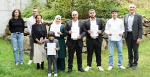 Ein Moment voller Stolz: Landrat Dr. Ronny Raith (rechts) überreichte Familie Alrefaee – (v. li.) Gad, Noura, Abdul Kader, Mahmoud und Maher – im Beisein von Yildiz Oragaz, Michael Spielbauer und Neele Hasselbach vom Ausländeramt die Einbürgerungsurkunden. Foto: Miriam Lange / Landratsamt Regen.