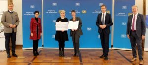 Die Schulleiterin Linda Langer (4.v.li.) und die Lehrerin Katrin Kuchler (3.v.li.) nahmen den Preis entgegen. Es gratulierten Bezirkstagspräsident und Laudator Dr. Olaf Heinrich (li.), die Integrationsbeauftragte der Bayerischen Staatsregierung Gudrun Brendel-Fischer, Regierungspräsident Rainer Haselbeck und der stellvertretende Landrat Helmut Plenk (re.). Foto: Katharina Kellnberger/Regierung von Niederbayern