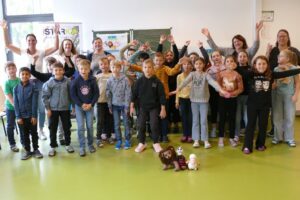 Die Klasse 3c trainiert mit bestimmten Bewegungen (Überkreuzbewegungen) das Zusammenspiel der beiden Gehirnhälften (hintere Reihe von links): Trainerin Karin Feilmeier, Klassenlehrerin Johanna Nausch, Jugendsozialarbeiterin Hilde Kreuzer, die Vorsitzende des Kinderschutzbundes Ursula Holzfurtner und Konrektorin Ulrike Häusler mit den Kindern der Klasse. Foto: Grundschule Regen