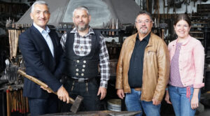 Foto: Schmiedekunst v.li.: Landrat Dr. Ronny Raith, Tobias Haselmayr, Ruhmannsfeldens Bürgermeister Werner Troiber und Wirtschaftsförderin Teresa Sitzberger hätten sich am liebsten gleich im Rahmen eines Schmiedekurses zusammen an die Esse gestellt.