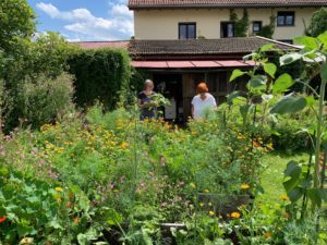 Rosi Wagenstaller und Conny Wilken betrachten die mit Gemüse bepflanzten Hochbeete. Dazwischen blühen Ringelblumen und Weidenröschen und locken Nützlinge an. Foto: Klaus Eder/Landkreis Regen