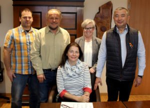 Nachdem Bożena Bogumiła Golz mit einer Fußverletzung zur Einbürgerung kam, durfte sie für das Erinnerungsfoto sitzen bleiben. Hinter ihr stehen (v.li.) Christian Raith (Landratsamt Regen), ihr Mann Bernhard Johannes Golz, Landrätin Rita Röhrl und Ciprian Vladimir Dobrei Vacarciuc.  Foto: Langer/Landkreis Regen