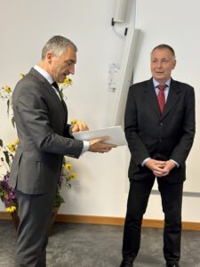 Landrat Dr. Ronny Raith überreicht die Kommunale Dankurkunde an Kirchbergs Bürgermeister Robert Muhr. Foto: Heiko Langer / Landratsamt Regen